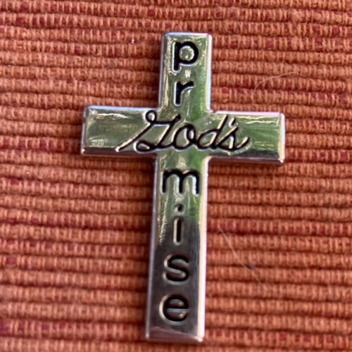 A silver cross with the words 