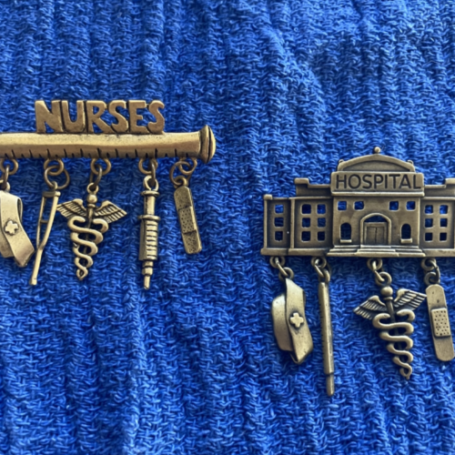 Two brass pins, one with the word 