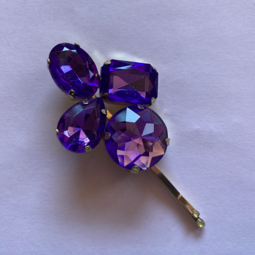 A hair pin with four purple gems