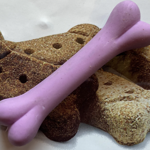 A photo of dog biscuits and a purple rubber dog bone