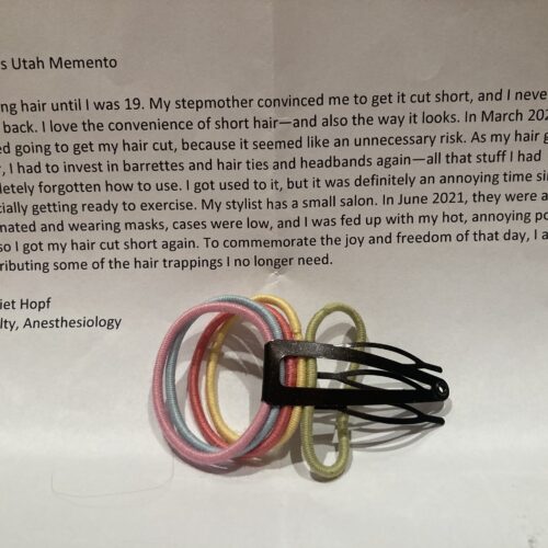 Photo of this story printed on a piece of paper with five hair ties and a hair clip