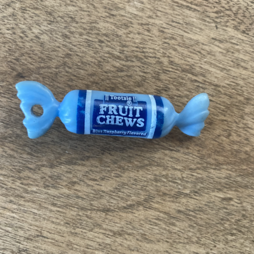 A photo of a blue, plastic mini tootsie roll