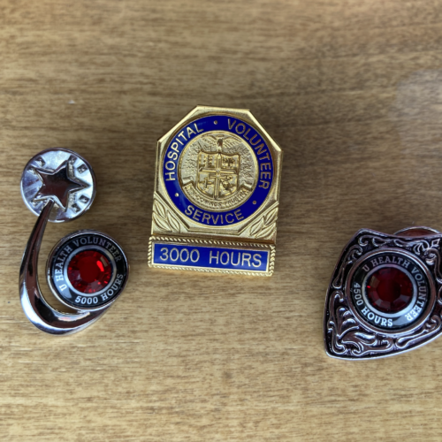 A photo of three pins with amount of hours volunteered by hospital volunteers