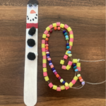 Photo of a popsicle stick snowman and multicolored beads on a string