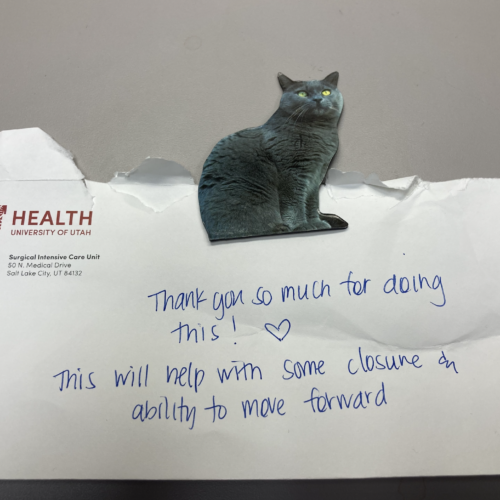 A photo of a cat magnet and an envelope with a handwritten note on it
