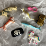 A photo of toy animals, ring, and car