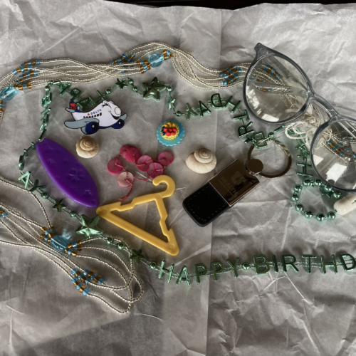 Photo of mini food, hanger, surfboard, shells, keychain, airplane, necklaces, glasses