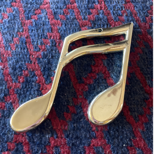 A photo of a gold musical note charm